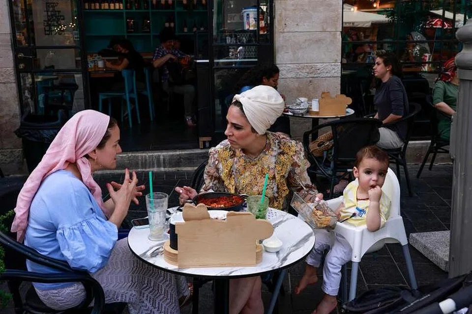 TIADA LAGI PELITUP: Wanita yang melanggani restoran di Jerusalem ini selesa berbual tanpa pelitup setelah pemerintah negara itu mengumumkan penduduk tidak lagi perlu menggunakan pelitup di tempat awam hasil jumlah kes jangkitan Covid-19 yang terkawal. - Foto AFP