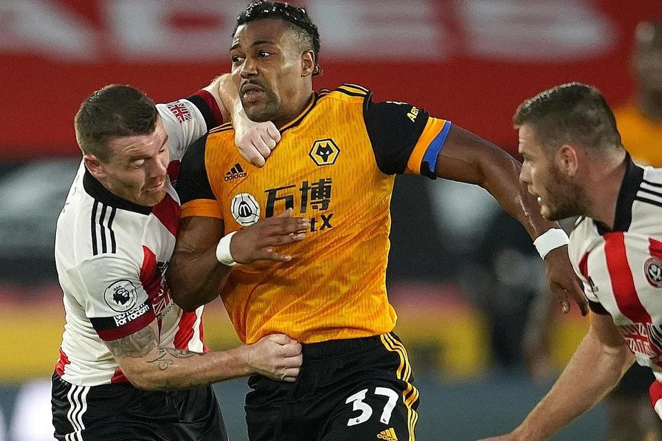 BERAKSI: Pemain Sheffield United Jack O'Connell (kiri) beraksi terhadap pemain Wolverhampton Wanderers Adama Traore dalam perlawanan yang memberi kemenangan 2-0 kepada Wolverhampton. - Foto EPA-EFE