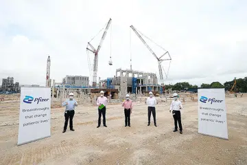 KOMITMEN KEPADA SINGAPURA: Encik Gan Kim Yong (tengah) bersama para pegawai EDB dan Pfizer di tapak kilang baru Pfizer di Tuas semalam. - Foto PFIZER