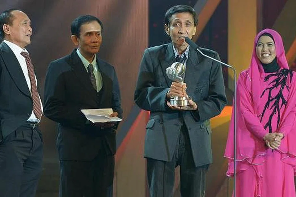 PENGHORMATAN TERTINGGI: Dua anggota A Ramlie and The Rhythm Boys, kketua dan bes gitar, Mohamad Ali Taib (kiri) dan adiknya pemain dram, Mohamad Arif Taib (kanan) serta penyanyi dan adik kepada Allahyarham A. Ramlie, A. Ramlan (tengah), menaiki pentas untuk menerima Anugerah Khas Planet Muzik. Menyampaikan anugerah tersebut ialah Ketua Penyiaran Melayu MediaCorp, Cik Zakiah Halim (kanan). - Foto TUKIMAN WARJI