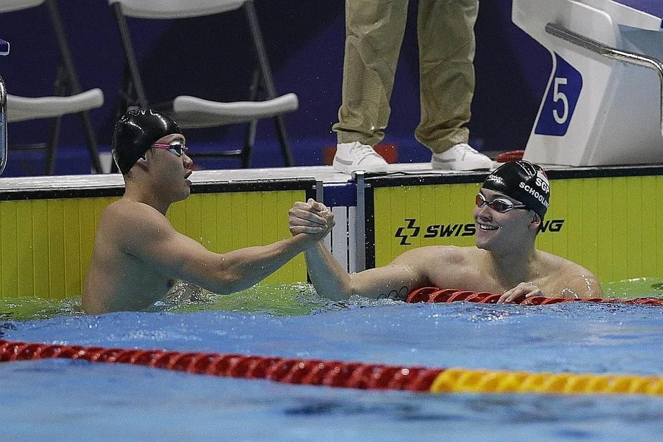 UCAP TAHNIAH: Joseph Schooling (kanan) ucapkan tahniah kepada rakan senegara Teong Tzen Wei atas kemenangan beliau dalam acara 50 meter gaya kupu-kupu. - Foto AP