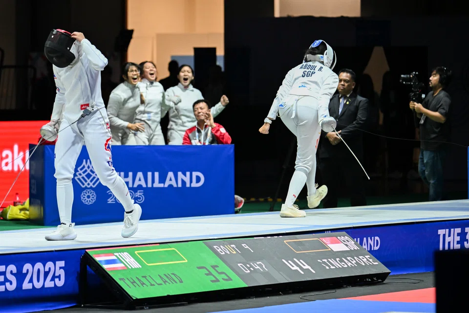 Kiria Tikanah (kanan) meraikan kejayaannya selepas mendapatkan kemenangan untuk Singapura di final acara ‘epee’ berpasukan wanita, dengan rakan sepasukannya dilihat turut meraikan kejayaannya itu. 