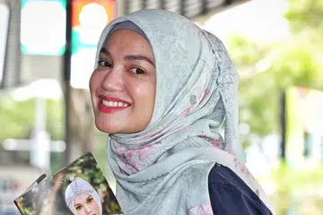 BUAT PENJELASAN: Puteri Sarah Liyana bersama buku mengenai kisah hidupnya, ‘Puteri Sarah: Terus Melangkah’. Beliau berkata vape yang kononnya dihisap beliau tidak mengandungi nikotin, hanya perisa guava.