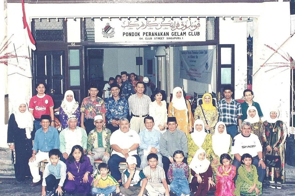 KENANGAN DI PONDOK: Keluarga besar Encik Abdul Sarip Naharawi (duduk, empat dari kanan) merakam gambar kenangan hari terakhir di rumah kedai di 64 Club Street, Chinatown, yang pernah menjadi markas dan tempat tinggal bagi seramai 40 kelamin dan 200 ahli pada satu ketika dulu. Rumah kedai itu diwarta sebagai salah satu bangunan bersejarah di Singapura pada 29 Januari 2000.