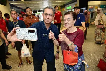 Pemangku Menteri Bertanggungjawab bagi Ehwal Masyarakat Islam, Dr Muhammad Faishal Ibrahim, yang juga Anggota Parlimen (AP) GRC Marine Parade–Braddell Heights bergambar di stesen MRT Eunos setelah set limau diagihkan sempena Tahun Baru Cina.