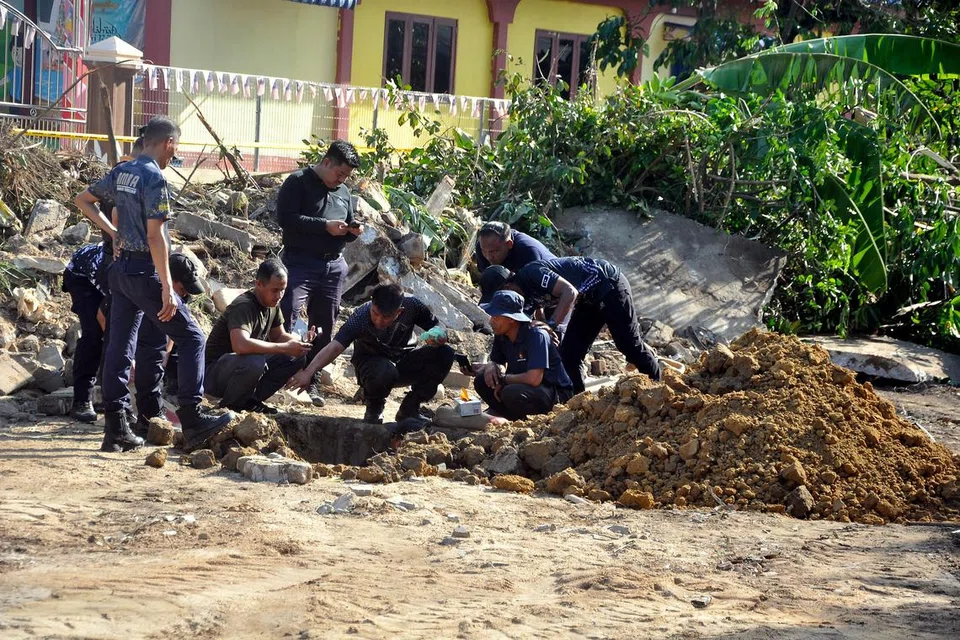 TELITI KEADAAN BOM: Unit Pemusnah Bom (UPB) Ibu Pejabat Polis Kontinjen (IPK) Terengganu meneliti lokasi tempat dua biji bom lama jenis mortar 60mm dan perlu diletupkan di belakang sebuah dewan terbuka berhampiran sebuah stesen minyak di Seberang Jertih.