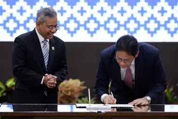 Menteri Kewangan Indonesia yang baru dilantik, Encik Suahasil Nazara (kiri), melihat mantan Menteri Kewangan, Encik Purbaya Yudhi Sadewa (kanan), menandatangani dokumen semasa upacara serah terima jawatan di Kementerian Kewangan di Jakarta pada 15 September 2026.