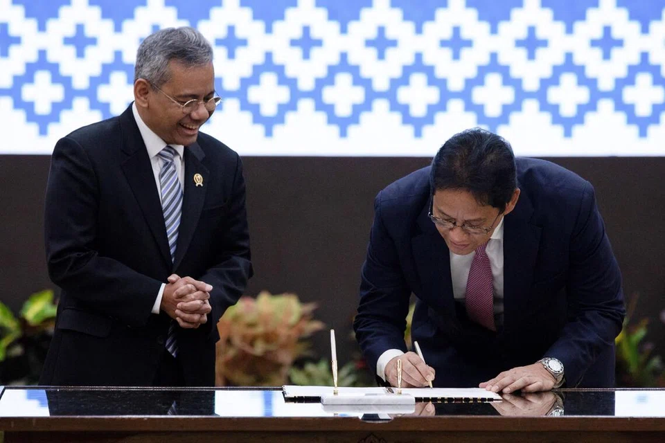 Menteri Kewangan Indonesia yang baru dilantik, Encik Suahasil Nazara (kiri), melihat mantan Menteri Kewangan, Encik Purbaya Yudhi Sadewa (kanan), menandatangani dokumen semasa upacara serah terima jawatan di Kementerian Kewangan di Jakarta pada 15 September 2026.