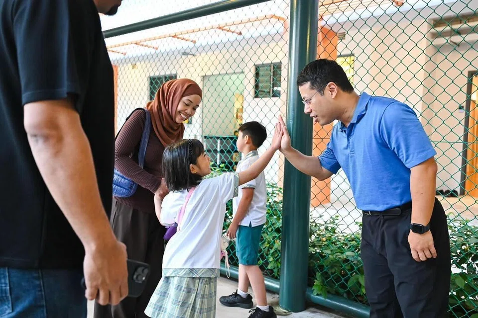 KEJUTAN ISTIMEWA: Menteri Pendidikan, Encik Desmond Lee (kanan), menyambut kedatangan murid Darjah 1 pada hari pertama persekolahan mereka di Sekolah Rendah Westwood di Jurong West.
