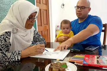KORBAN UNTUK IBU: Encik Muzhafar (kanan) yang mendukung anaknya Muhd Umar, sering menghabiskan masa melayani ibunya, Cik Zainab (kiri) yang menghidap demensia dan telah menerima bayaran ElderShield sejak sekitar dua tahun lalu. - Foto ihsan MUZHAFAR MAROF