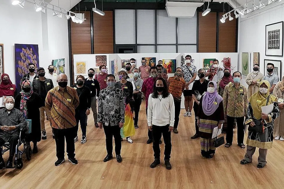 KETENGAH HASIL SENI BAKAT SETEMPAT: Dr Mohamad Maliki Osman (barisan depan, tiga dari kiri) bersama karyawan seni lukis dan visual setempat semasa majlis pelancaran, pameran SeniKita di studio Kamal Arts yang terletak di WGS pada Jumaat lalu. - Foto BH oleh KHALID BABA