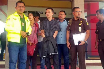 Lim Yong Nam (tengah) dibawa pegawai dan pegawai polis di Batam ke lapangan terbang untuk diekstradisi ke Amerika pada 31 Mac lalu. F PANGESTU