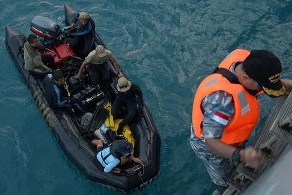 USAHA CARI BANGKAI PESAWAT: Penyelam Tentera Laut Indonesia bersiap untuk berlepas ke kapal KRI Banda Aceh untuk menjalankan operasi mengapung ekor pesawat QZ8501. - Foto AFP