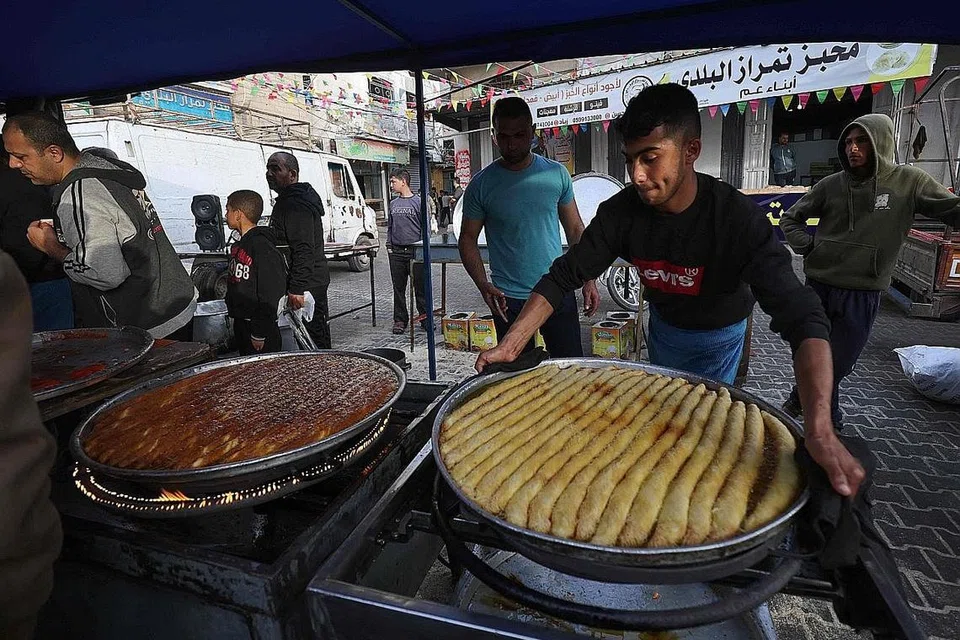 MANISAN BERBUKA: Seorang pekedai di Palestin menempatkan makanan manisan yang digemari ramai di sebuah pasar sebelum tibanya masa berbuka puasa di bandar Rafah, Jaluran Gaza. - Foto AFP 