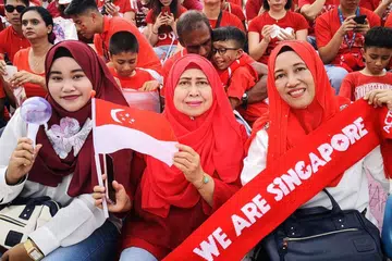 GHAIRAH: (Dari kiri) Cik Nur Farisyah Suparman, Cik Rohana Abdul Gani dan Cik Saleha Basri gembira dapat menyaksikan NDP secara langsung di Pentas Terapung Marina Bay semalam. Mereka keluar rumah seawal 1.30 petang supaya tidak perlu beratur panjang. - Foto BH oleh ERVINA MOHD JAMIL 