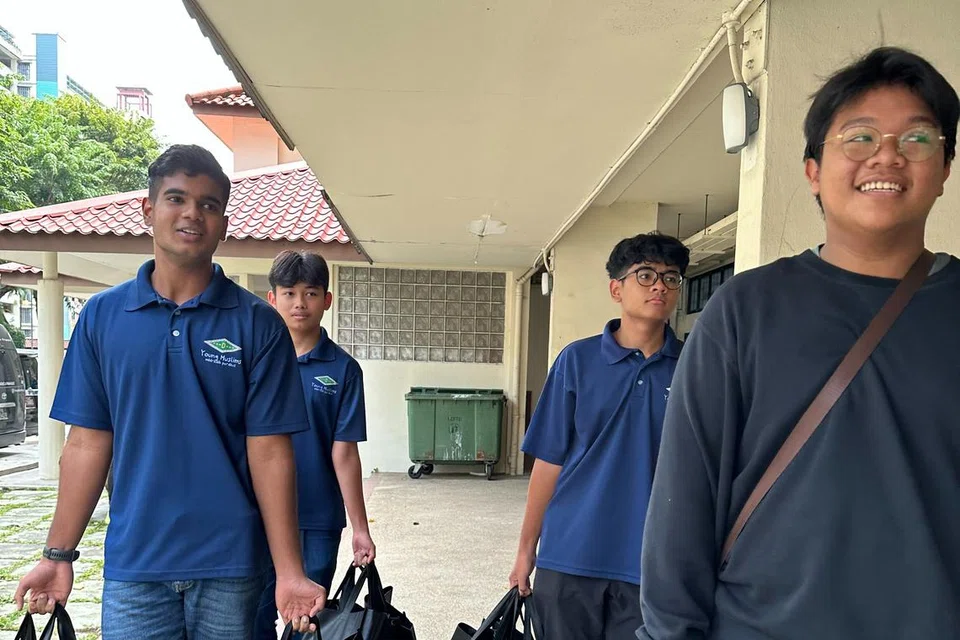 Pelajar Madrasah Perdaus membantu mengagih barangan keperluan Raya kepada penerima dan keluarga yang memerlukan pada 2023. 