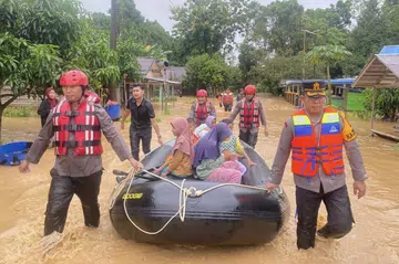Pasukan penyelamat memindahkan penduduk yang terjejas akibat banjir pada 27 Disember di Tebing Tinggi, Balangan, Kalimantan Selatan.