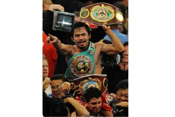 GELAR JUARA: Encik Pacquiao dengan pelbagai tali pinggang juara meraikan kemenangan selepas mengatasi peninju Puerto Rico, Miguel Angel Cotto, dalam pertarungan WBO kelas welterweight di MGM Grand Garden Arena di Las Vegas, Nevada, pada 14 November 2009. - Foto AFP