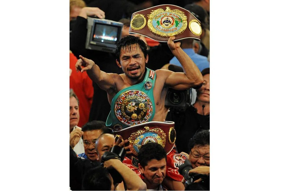 GELAR JUARA: Encik Pacquiao dengan pelbagai tali pinggang juara meraikan kemenangan selepas mengatasi peninju Puerto Rico, Miguel Angel Cotto, dalam pertarungan WBO kelas welterweight di MGM Grand Garden Arena di Las Vegas, Nevada, pada 14 November 2009. - Foto AFP