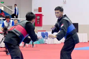Pesilat Singapura Abdul Raazaq (kanan) mengalahkan juara dunia tiga kali Malaysia, Mohd Al Jufferi Jamari 26-21 dalam separuh akhir acara tanding putera kelas F (70-75kg) di Hanoi pada hari ini. 