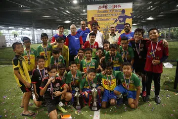 JUARA PERTANDINGAN: Juara keseluruhan bagi pertandingan utama, Buona Vista A Team, bersama Encik S Chandradas (belakang, dua dari kanan), Encik Anthony Tan (belakang, paling kiri), Encik Rajendran Jawharilal (belakang, tiga dari kiri), Encik K Ramamoorthy (belakang, dua dari kiri) dan Editor Bersekutu Tamil Murasu, Encik V Palanisamy (belakang, paling kanan).