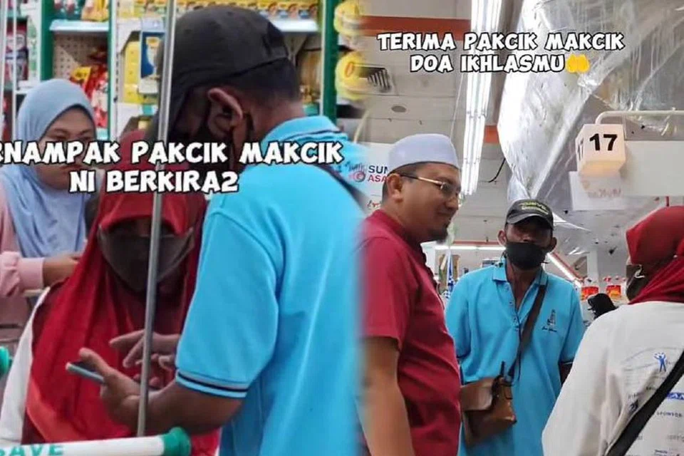 Encik Muhammad Ismail Sajiman (berbaju merah) membantu pasangan suami isteri yang kekurangan wang ketika membeli barangan keperluan menjelang Aidilfitri. 