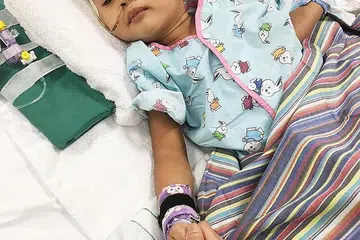 SEBAK DENGAN NASIB ANAK: Cik Ira, seorang warga Malaysia, sebak dengan nasib yang menimpa anaknya yang berusia dua tahun, Muhd Raffique Rayfal Mohd Nasharuddin (gambar atas), yang sebelum ini sihat dan aktif, kini terlantar di Unit Jagaan Rapi (ICU) Hospital Universiti Nasional (NUH). Di sebelah Cik Ira ialah adik beliau, Encik Amy Recha. - Foto FACEBOOK AMY RECHA