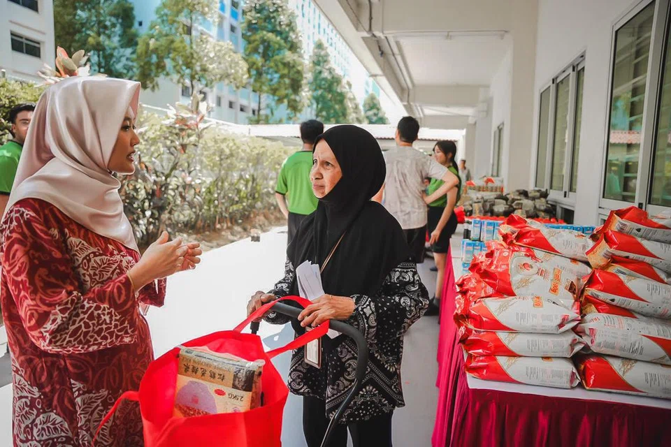 Menteri Negara (Penerangan dan Pembangunan Digital merangkap Kesihatan), Cik Rahayu Mahzam (kiri) dan Cik Mariam membantu penerima semasa pengagihan barangan runcit pada Ramadan 2024.