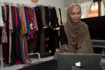DITONTON DI SERATA DUNIA: Sesi penjualan 'live' Cik Norsiah Borhan (atas) telah menarik perhatian peniaga sejauh Jordan dan Dubai. - Foto BH oleh SYAMIL SAPARI