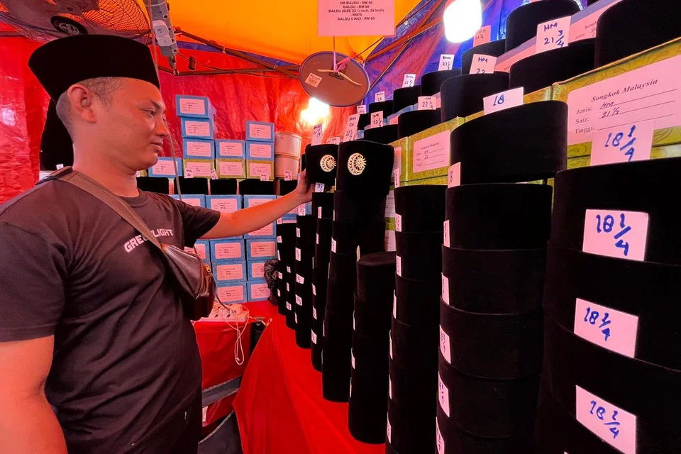 Pekerja gerai menjual songkok milik Cik Nur Erya Talib, 32 tahun, menyusun songkok yang dijual di bazar Aidilfitri Lorong TAR. Gerai Cik Nur Erya antara yang rosak akibat dibadai ribut baru-baru ini.