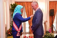 DIBERI PENGIKTIRAFAN: Sir Andrew Witty (kanan) diberi penghormatan sebagai warga negara kehormat Singapura atas sumbangan beliau kepada pembangunan ekonomi. Anugerah itu disampaikan Presiden Halimah Yacob. - Foto BH oleh DESMOND WEE