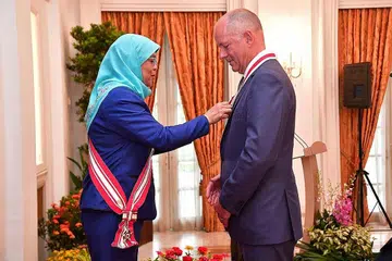 DIBERI PENGIKTIRAFAN: Sir Andrew Witty (kanan) diberi penghormatan sebagai warga negara kehormat Singapura atas sumbangan beliau kepada pembangunan ekonomi. Anugerah itu disampaikan Presiden Halimah Yacob. - Foto BH oleh DESMOND WEE