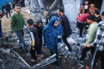 LEBIH RAMAI TERKORBAN: Penduduk Palestin memeriksa kerosakan selepas pengeboman Israel ke atas Rafah di selatan Gaza pada 3 Disember.