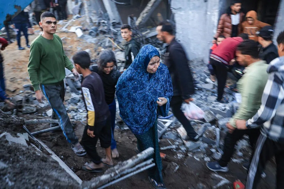LEBIH RAMAI TERKORBAN: Penduduk Palestin memeriksa kerosakan selepas pengeboman Israel ke atas Rafah di selatan Gaza pada 3 Disember.