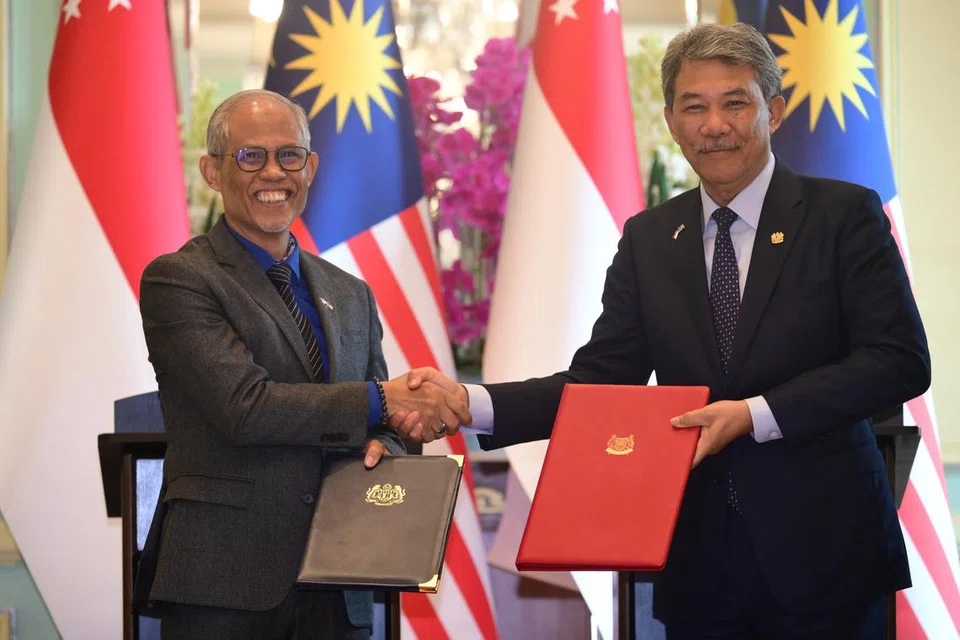 Menteri Pembangunan Sosial dan Keluarga, Encik Masagos Zulkifli Masagos Mohamad (kiri) bertukar perjanjian bagi memperdalam kerjasama dalam aspek kebajikan sosial, wanita, orang kurang upaya (PWD), keluarga, kanak-kanak dan pembangunan masyarakat bersama Menteri Ehwal Luar Malaysia, Datuk Seri Mohamad Hasan.