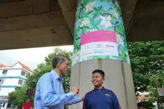 Pemangku Menteri Bertanggungjawab bagi Ehwal Masyarakat Islam serta Anggota Parlimen bagi GRC Marine Parade-Braddell Heights (Kembangan), Profesor Madya Dr Muhammad Faishal Ibrahim (kiri) beramah mesra bersama Nur Muhammad Darwish Mohammad Ridzwan, 14 tahun, salah seorang daripada 12 pelajar MINDS Towner Gardens School (TGS) yang menyumbang kepada penghasilan pemasangan seni awam Trainforest di stesen MRT Kembangan.