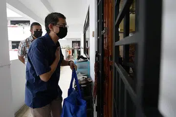 PENGAGIHAN KORBAN: Dr Faishal mengagihkan daging kepada salah satu keluarga dari 4,800 keluarga yang memanfaat daripada pengagihan daging korban tahun ini oleh Jawatankuasa Korban Masjid-Masjid Singapura (JKMS). - Foto BM oleh NG SOR LUAN