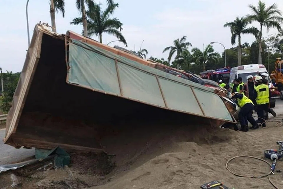 BERJAYA DIBEBASKAN: Pemandu trak yang tersepit dalam traknya akibat kemalangan di lebuh raya ECP semalam berjaya dibebaskan oleh penyelamat Dart SCDF dalam operasi yang mengambil masa 3½ jam. -Foto SINGAPORE CIVIL DEFENCE FORCE/FACEBOOK. 
