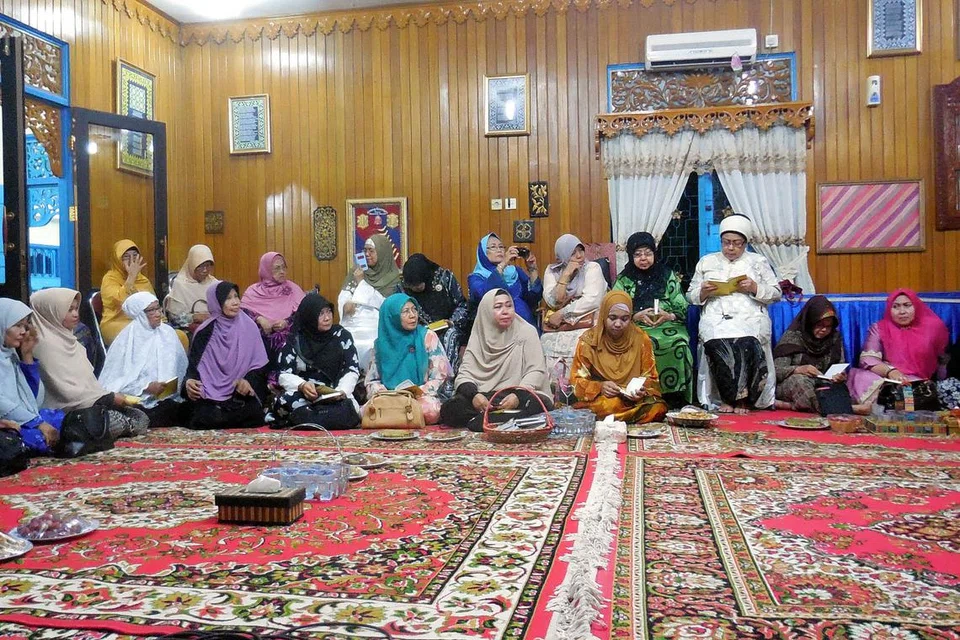 TAHLIL: Majlis tahlil Almarhum Tenas Effendy di rumahnya atau lebih tepat di ruang kerjanya. Majlis itu dihadiri saudara-mara dan sahabat-handai, termasuk ilmiawan Malaysia. Kelihatan balu Almarhum, Tengku Zahara Tengku Long Mahmud (duduk di kerusi ketiga dari kiri, bertudung merah jambu). - Foto MOHD RAMAN DAUD. 