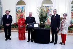 NAMA ORKID SEMPENA LAWATAN DIABADI: Sultan Ibrahim dan isteri, Raja Zarith Sofiah (kededuanya paling kiri), dihadiahkan bunga orkid yang mengabadikan nama mereka - Dendrobium Ibrahim Zarith - sebagai penghormatan di atas lawatan rasmi Sultan ke Singapura. Turut dalam gambar ialah PM Lee dan isteri. - Foto MCI
