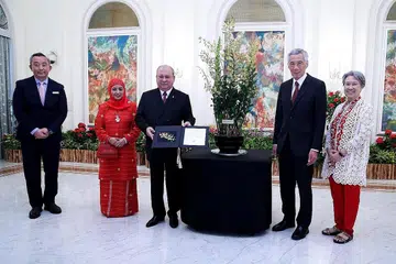 NAMA ORKID SEMPENA LAWATAN DIABADI: Sultan Ibrahim dan isteri, Raja Zarith Sofiah (kededuanya paling kiri), dihadiahkan bunga orkid yang mengabadikan nama mereka - Dendrobium Ibrahim Zarith - sebagai penghormatan di atas lawatan rasmi Sultan ke Singapura. Turut dalam gambar ialah PM Lee dan isteri. - Foto MCI