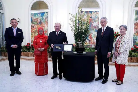 NAMA ORKID SEMPENA LAWATAN DIABADI: Sultan Ibrahim dan isteri, Raja Zarith Sofiah (kededuanya paling kiri), dihadiahkan bunga orkid yang mengabadikan nama mereka - Dendrobium Ibrahim Zarith - sebagai penghormatan di atas lawatan rasmi Sultan ke Singapura. Turut dalam gambar ialah PM Lee dan isteri. - Foto MCI