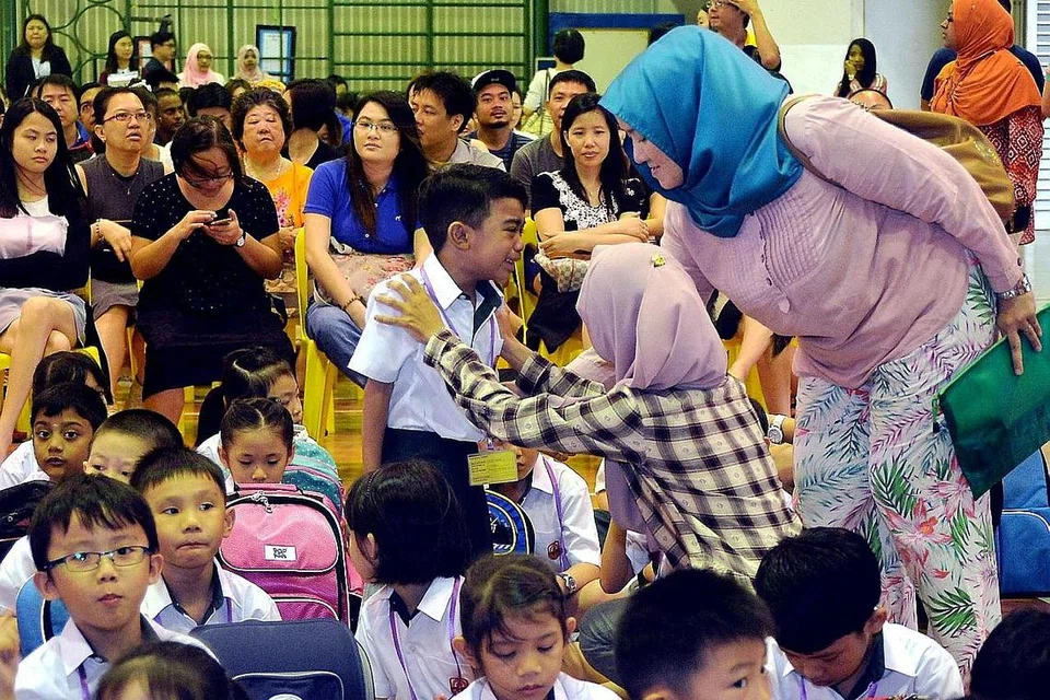 SEKITARAN BARU: Seorang murid darjah satu Sekolah Rendah Princess Elizabeth yang sedang menangis dipujuk guru. - Foto KHALID BABA