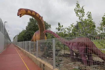 SERONOK 'DITEMANI' DINOSAUR: Tarikan utama laluan baru yang dirasmikan semalam termasuk 20 dinosaur yang 'menemani' pengunjung sepanjang laluan sejauh 3.5 kilometer itu. - Foto BH oleh ONG WEE JIN