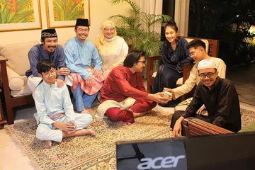 CUBA MULA TRADISI BARU: Encik Zainal Sapari sekeluarga, termasuk isteri, Cik Sazurah Mahmood (bertudung), dan anak-anaknya - Sarah, Ismail (baju biru gelap), Isa (baju kuning air), Ahmad Fitri (baju merah manggis), Azman (baju biru air) dan Abdullah (jubah hitam) - akan berpuasa enam bersama semasa Hari Raya ini dan melakukan panggilan Zoom bersama keluarga besar mereka untuk menyemarakkan suasana pagi Hari Raya di rumah. - Foto ihsan ZAINAL SAPARI