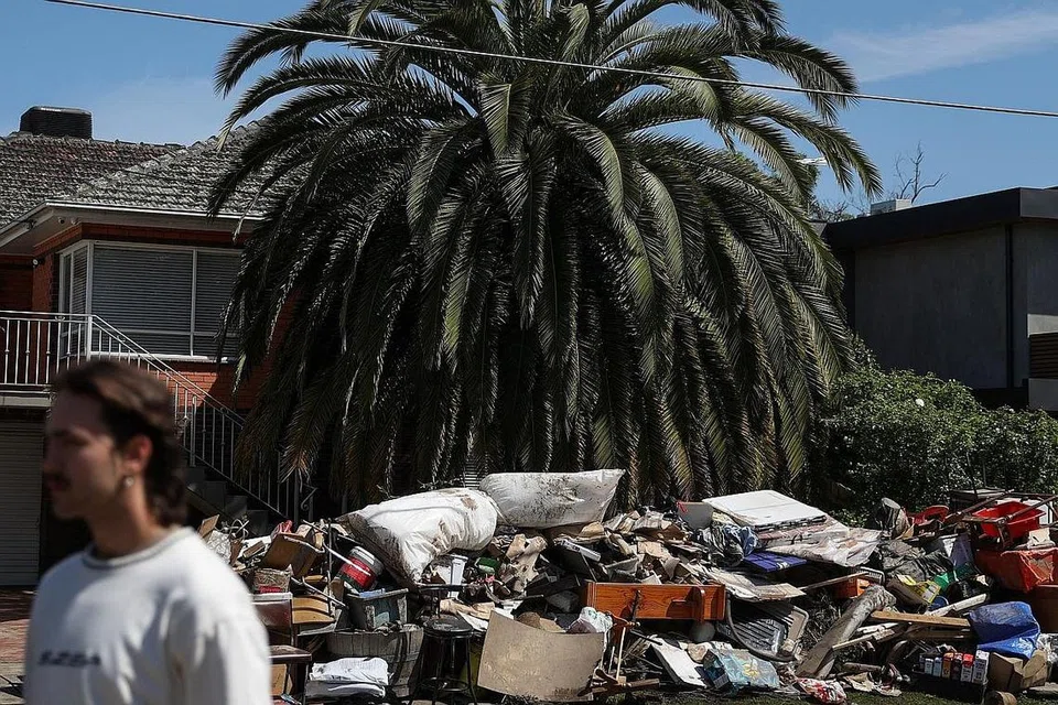 ANGKARA BANJIR: Pemilik rumah di bandar Maribyrnong di Melbourne meletakkan perabot dan barangan rumah yang rosak akibat banjir di luar rumah mereka. - Foto REUTERS