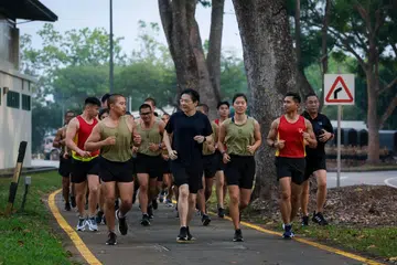 Perdana Menteri, Encik Lawrence Wong (barisan depan, dua dari kiri), berlari bersama rekrut SAF semasa lawatan beliau ke Pusat Latihan Asas Tentera (BMTC) di Pulau Tekong.