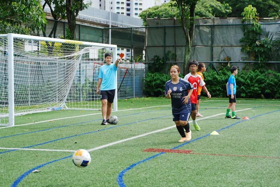 KLINIK BOLA SEPAK: Putri Qaleysha Edora Muhammad Firdaus (dua dari kiri) gembira berpeluang mengambil bahagian dalam Klinik Bola Sepak @ South East pada awal pagi 13 Disember 2025 di Sekolah Rendah Bedok Green.
