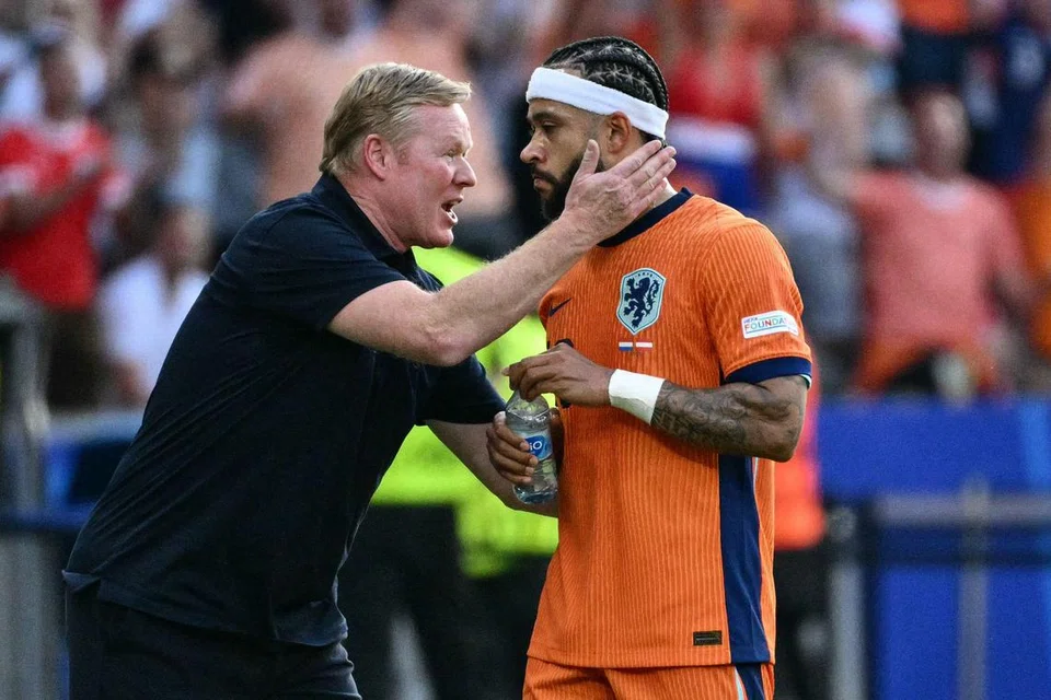 Memphis Depay (kanan) menerima kata-kata perangsang daripada ketua jurulatih skuad Belanda, Ronald Koeman, setelah menjaringkan gol kedua dalam perlawanan menentang Austria dalam Euro 2024 pada 25 Jun.