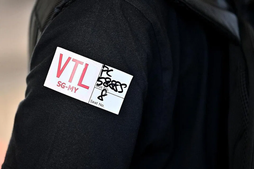 PELEKAT VTL: (Foto sisipan) Setiap penumpang yang menaiki bas yang dikhususkan bagi VTL (Darat) diberi pelekat antara lain untuk mengenal pasti diri mereka, nombor bas serta tempat duduk mereka.